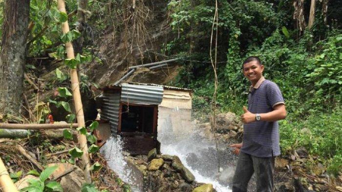 Harianto Albarr dari Desa Bacu-Bacu di depan turbin pembangkit listrik